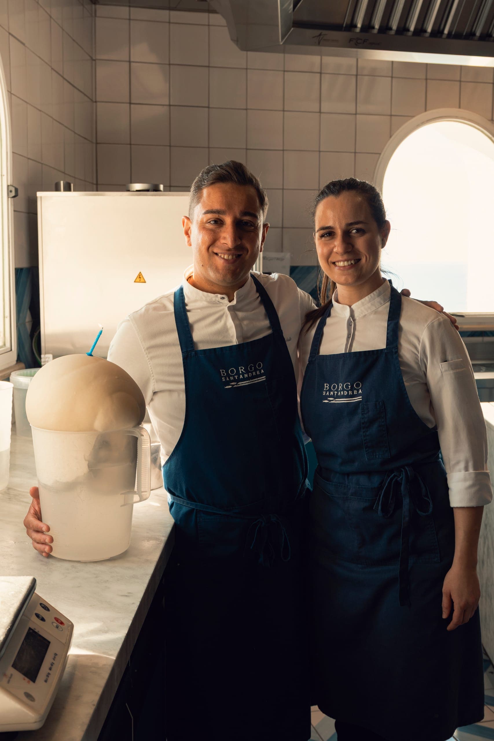 Due pasticcieri sorridono accanto al secchio con l'impasto lievitato.