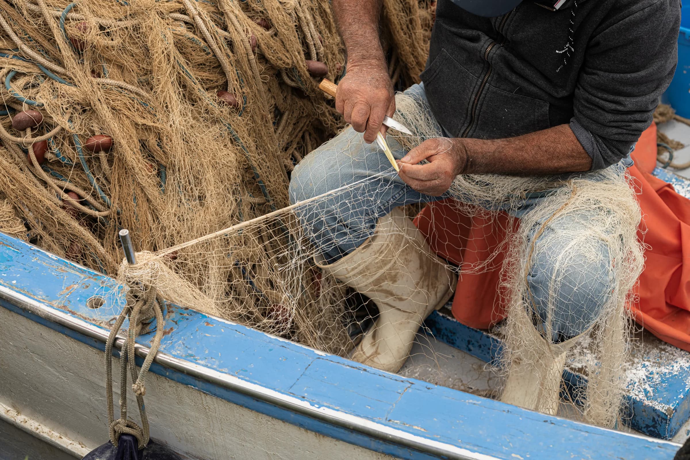 Le mani di un pescatore al lavoro